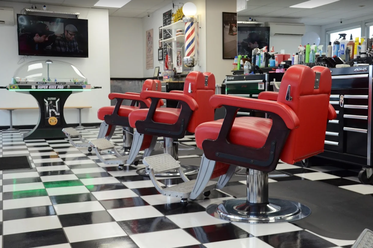 Inside The Fade Factory — red barber chairs and checkered floor