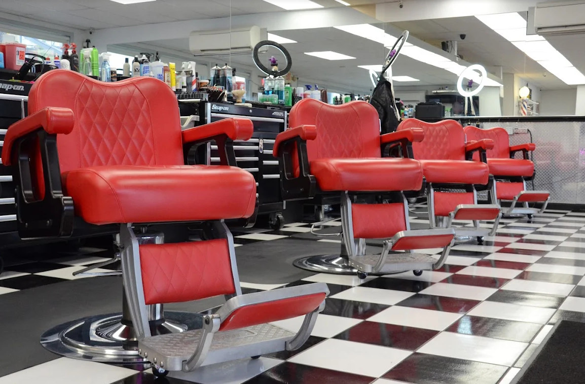 Row of classic red barber chairs at The Fade Factory
